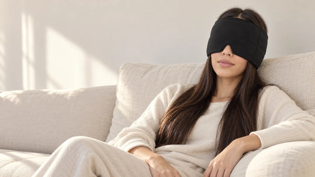 Cryovelle Therapy Mask — Midnight Black, worn by a woman relaxing on a sofa